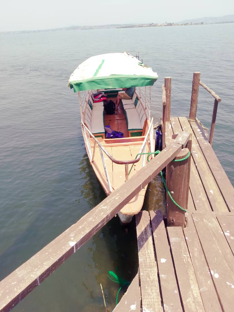 Wooden cruise boat with green canopy tied at the jetty