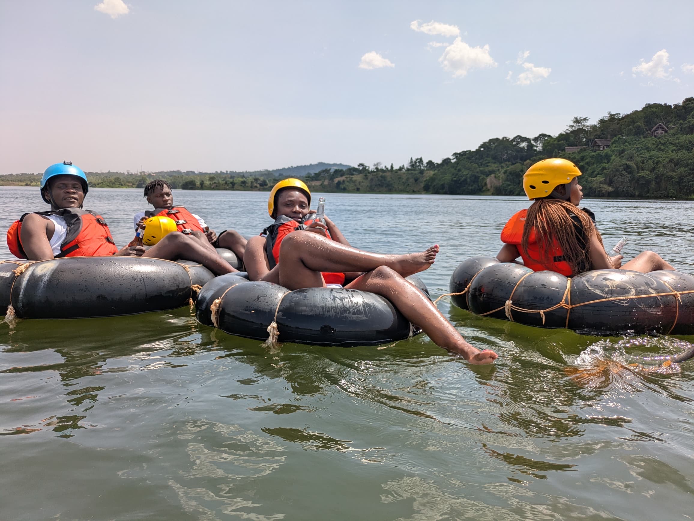 Four tubers on the Nile with lush green hills in the background