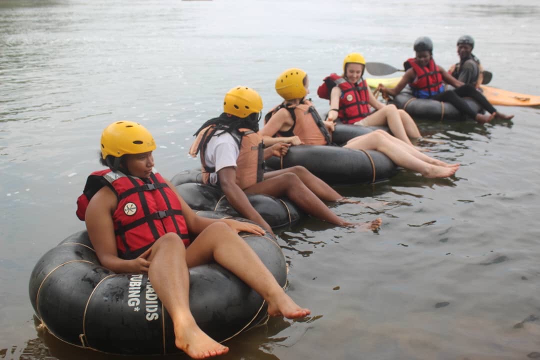 Group of tubers in yellow helmets and red life jackets lined up on the Nile